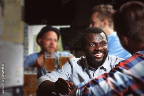 Young men drinking beer in pub