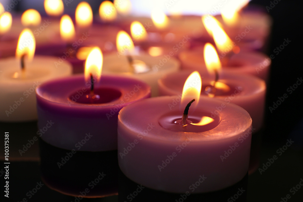 Many burning small candles on dark background, close-up Many burning small candles on dark background, close-up