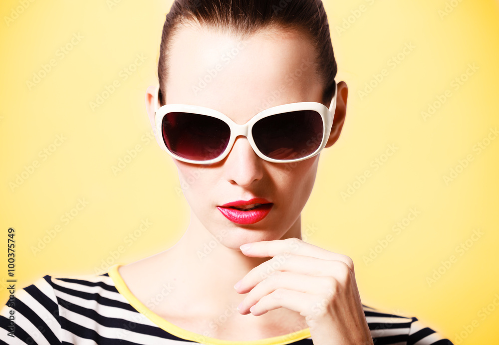 Fototapeta premium Fashion model striking a pose wearing sunglasses. 