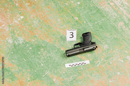 murder gun lying on the floor. crime scene photo