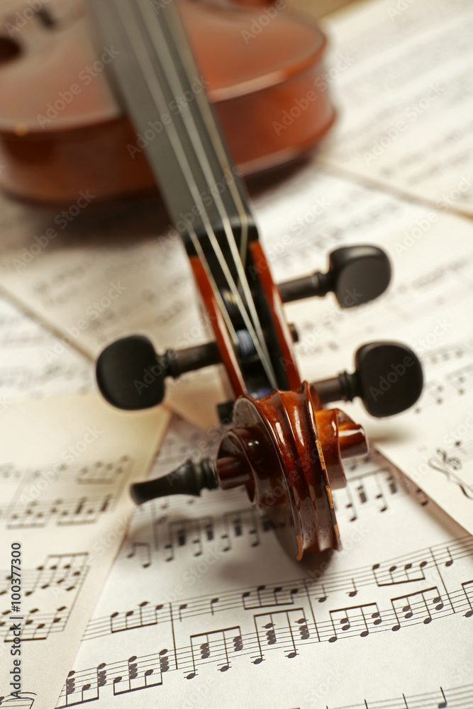 Fototapeta premium Violin neck on music papers background