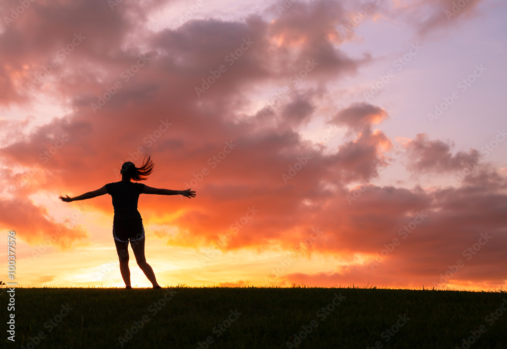 Happy woman jumping against sunset. Freedom concept. Enjoyment.
