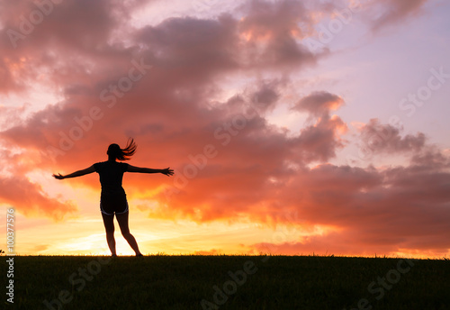 Happy woman jumping against sunset. Freedom concept. Enjoyment. 