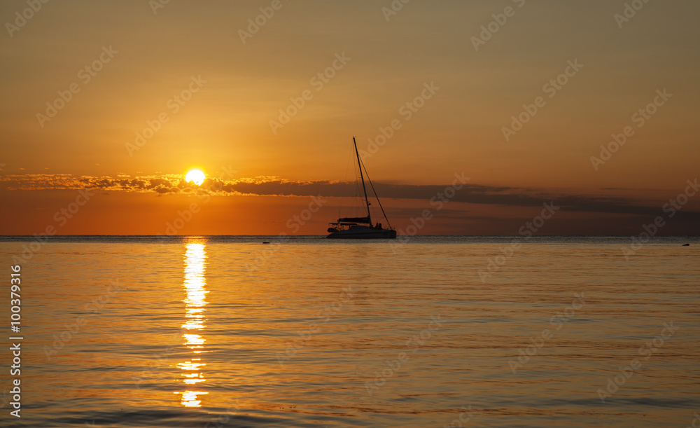 ocean sunset with boat sailing
