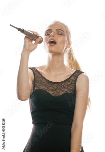 young pretty blond woman singing in microphone isolated close up black dress, karaoke girl