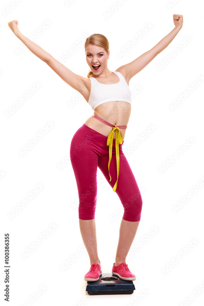 Woman measuring on weighing scale with raised arms Woman measuring on weighing scale with raised arms