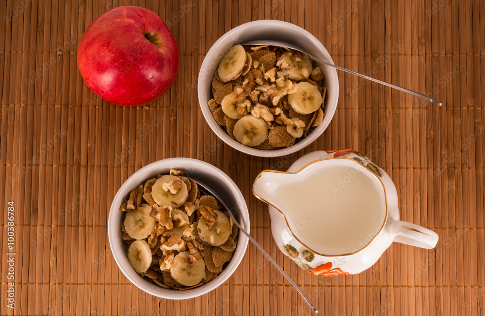 Two bowls of cereal, walnuts, banana and apple Two bowls of cereal, walnuts, banana and apple