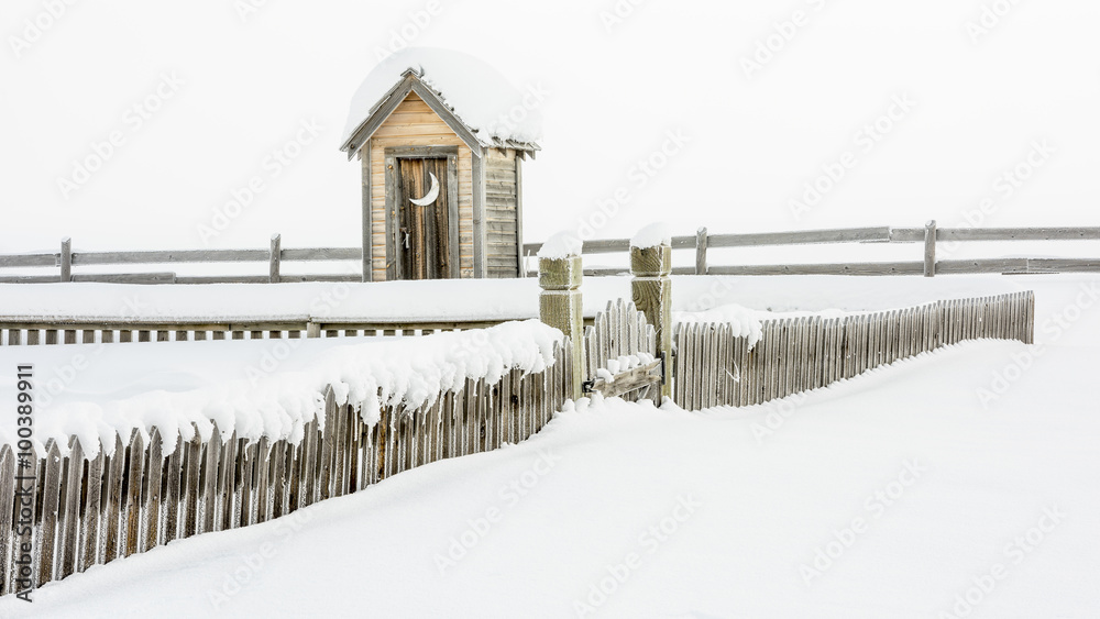 Winter snow and frost on a fence and outhouse Winter snow and frost on a fence and outhouse