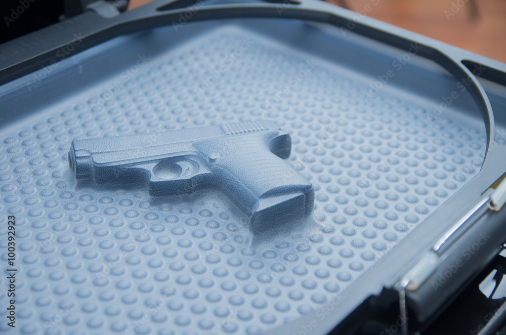 Black toy gun lying on  plastiv bubble surface, print screen process