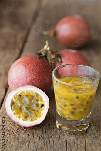 Passion fruits with glass of passion fruit juices on wooden
