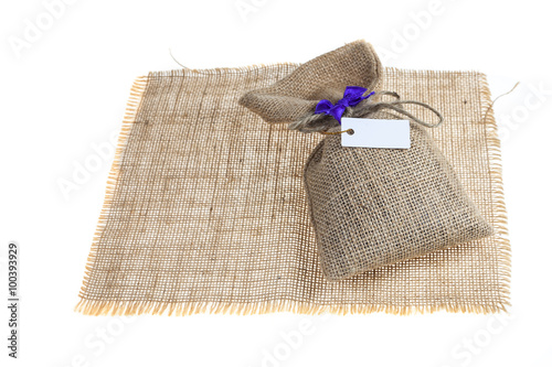 Gift in hemp sack with blank label on white background.