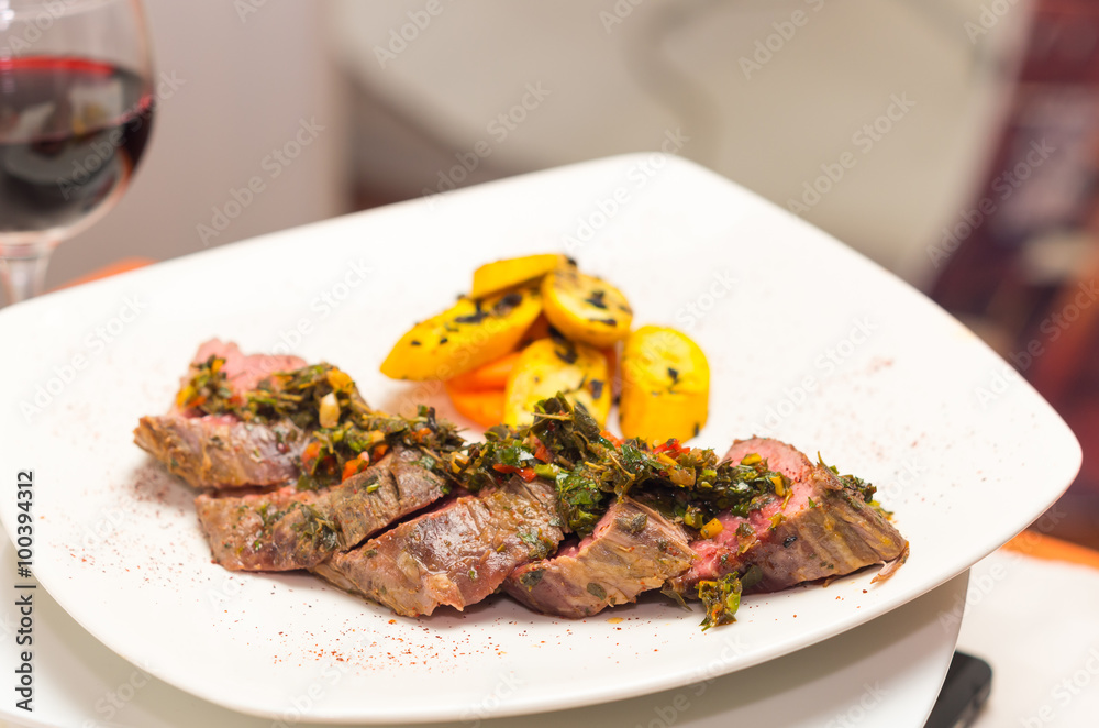 Delicious medallions of tenderloin steak placed upon white dinner plate with some vegetables next to it, elegant presentation Delicious medallions of tenderloin steak placed upon white dinner plate with some vegetables next to it, elegant presentation