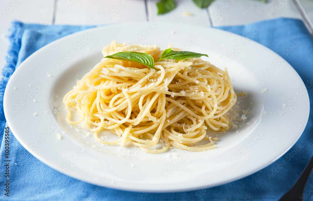 spaghetti with parmesan cheese and basil in plate