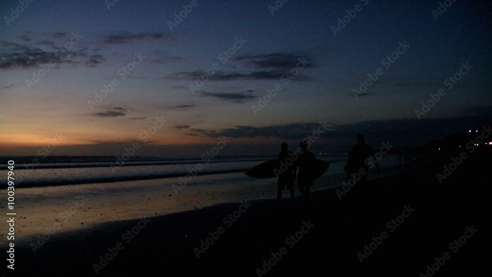 Pan of surfers and a beach after sunset in Bali. Pan of surfers and a beach after sunset in Bali.