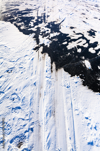 ski tracks on surface of frozen river in winter