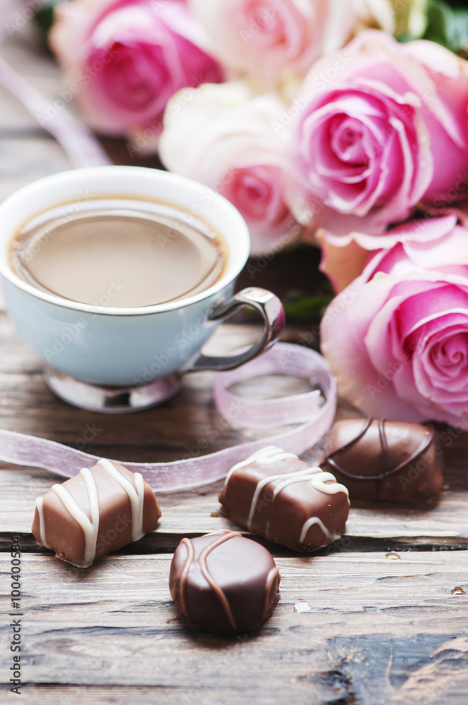 Pink roses, coffe and chocolate on the wooden table - obrazy, fototapety, plakaty 