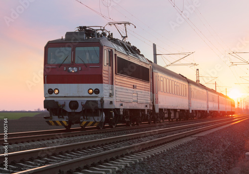 Passenger train on railway at sunset