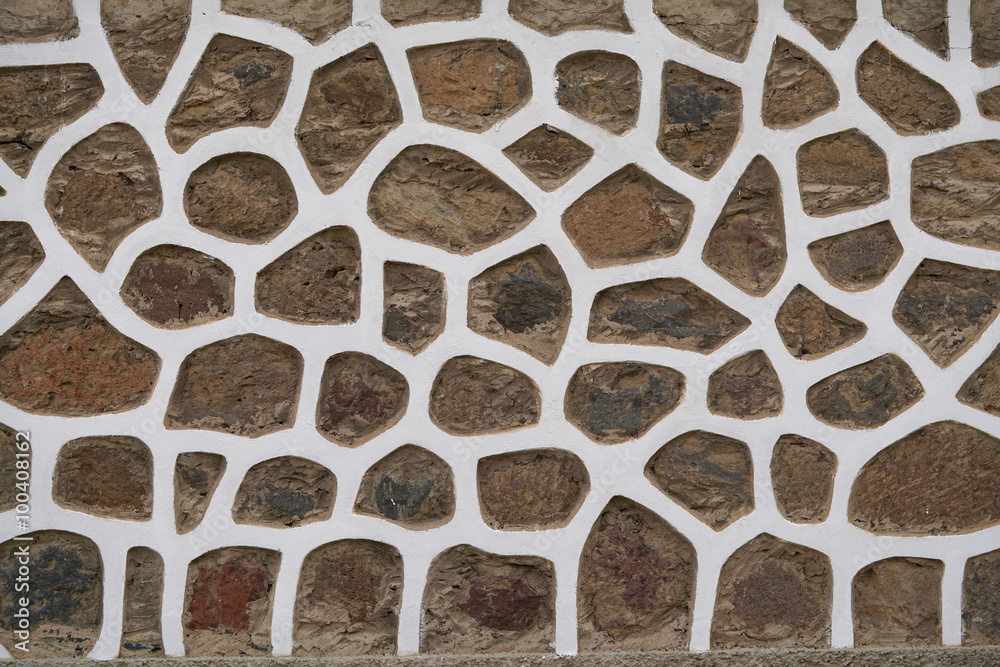Fototapeta premium wall of brown stones in whtie stucco