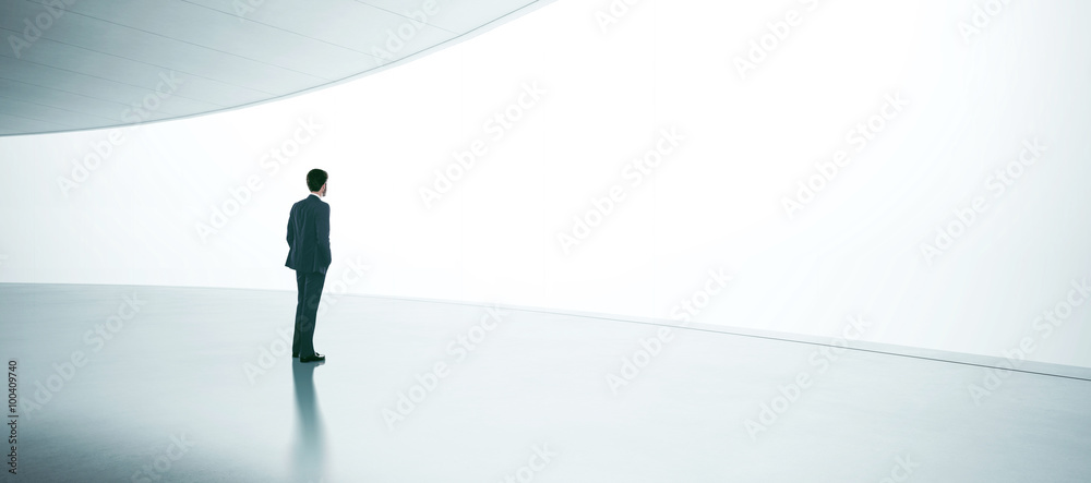 Obraz premium Young businessman wearing suit and stands in the open space interior