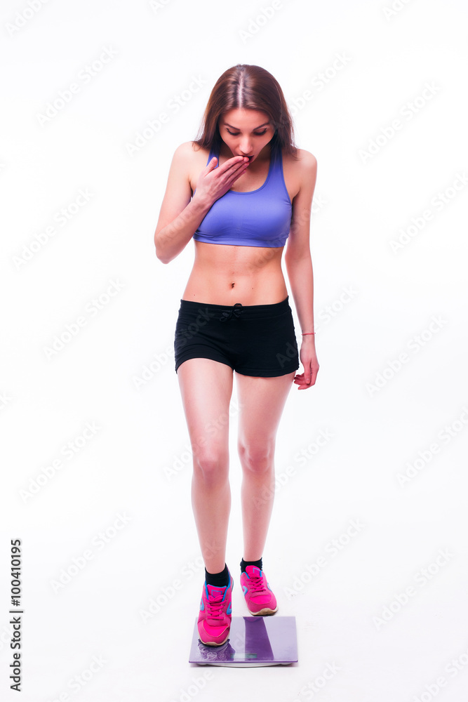 Sport girl Measuring Body Weight On Weighing Scale isolated on white background. Health concept Sport girl Measuring Body Weight On Weighing Scale isolated on white background. Health concept