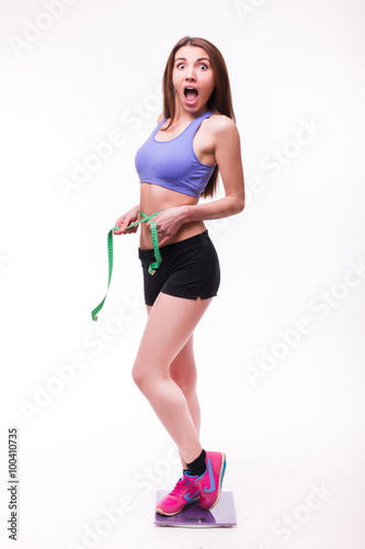 Fit and healthy young lady measuring her waist with a tape measure in centimeters and millimeters. Isolated image on white. © F8  \ Suport Ukraine