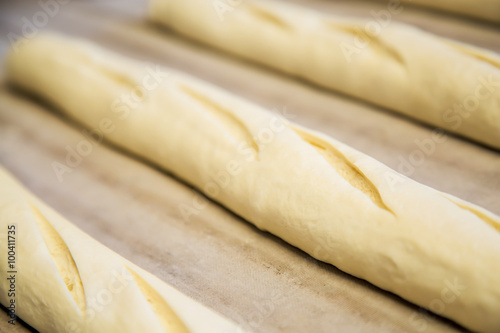 A plain baguette ready to bake on baking tray