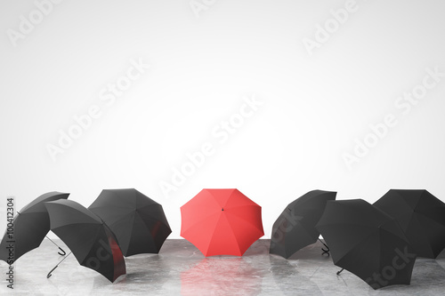 To be unique concept with many black umbrellas and one red on co