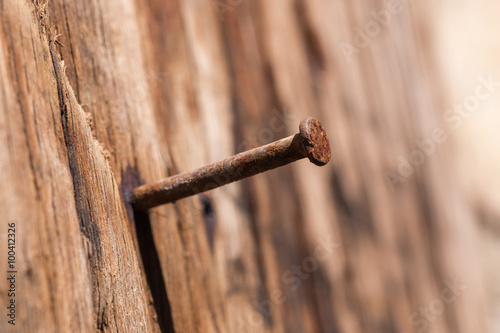 A rusty nail in a wooden board