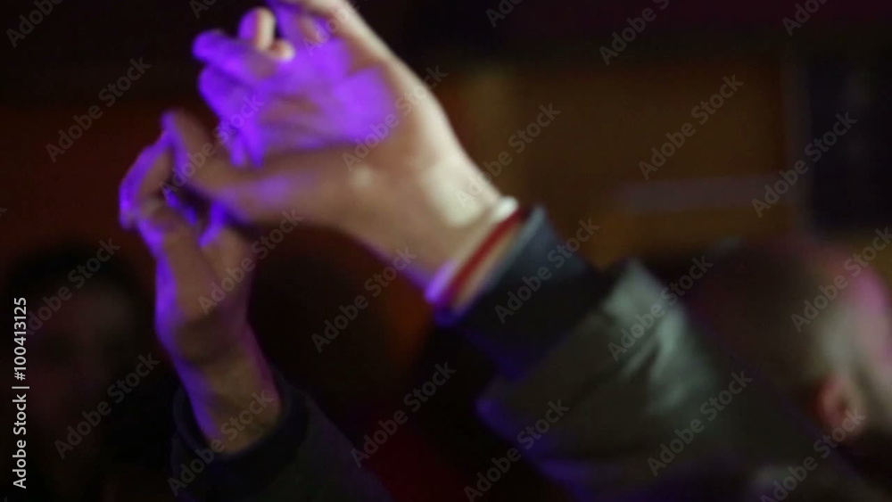 Hands of a Young Man Dancing in a Night Disco Club. Shallow deep of Field. Pink Light Illumination. 