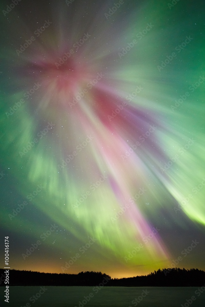 Northern lights and  green aurora corona in the cold winter sky.