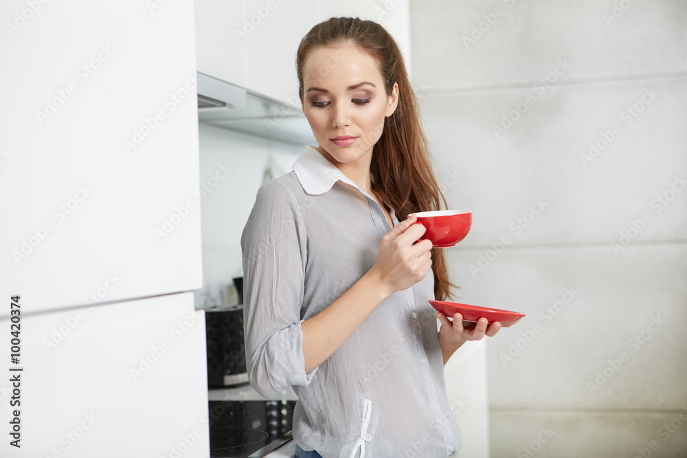 Woman drinking morning coffee in the kitchen