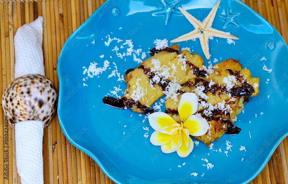 grilled bananas topped with chocolate and coconut powder