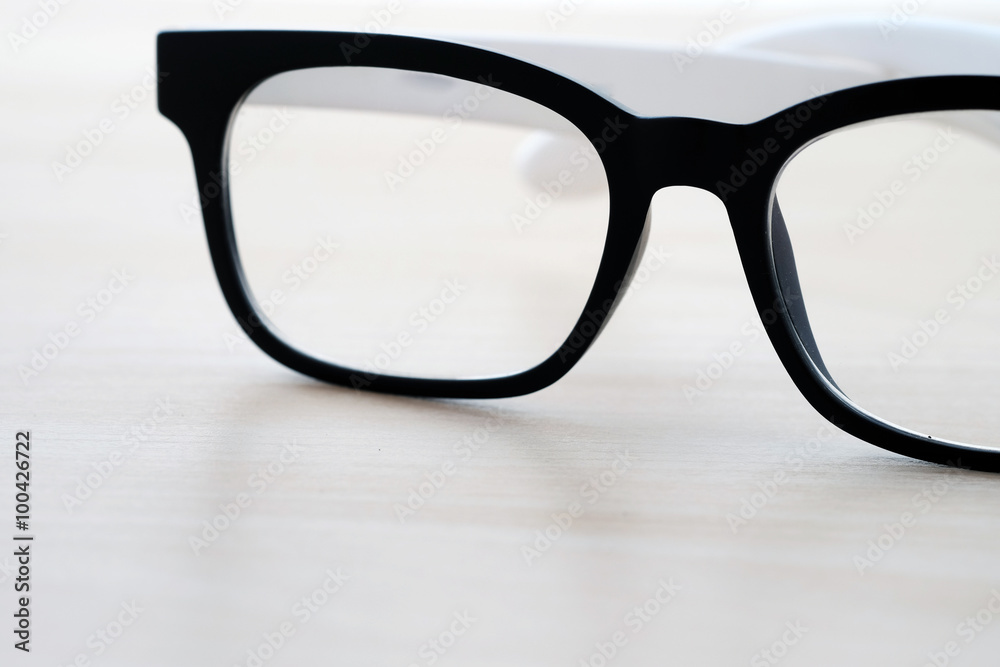 Eye glasses on wooden table, black and white tone