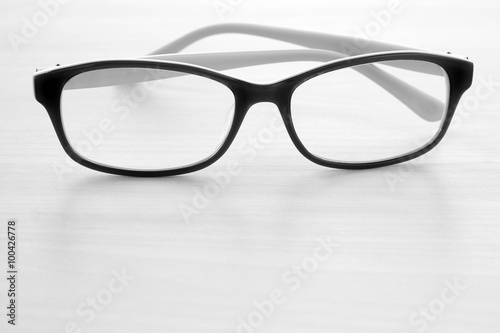 Eye glasses on wooden table, black and white tone