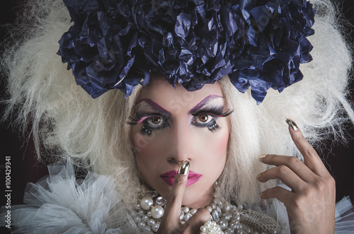 Drag queen with spectacular makeup, glamorous trashy look, posing while using hands and fingers photo