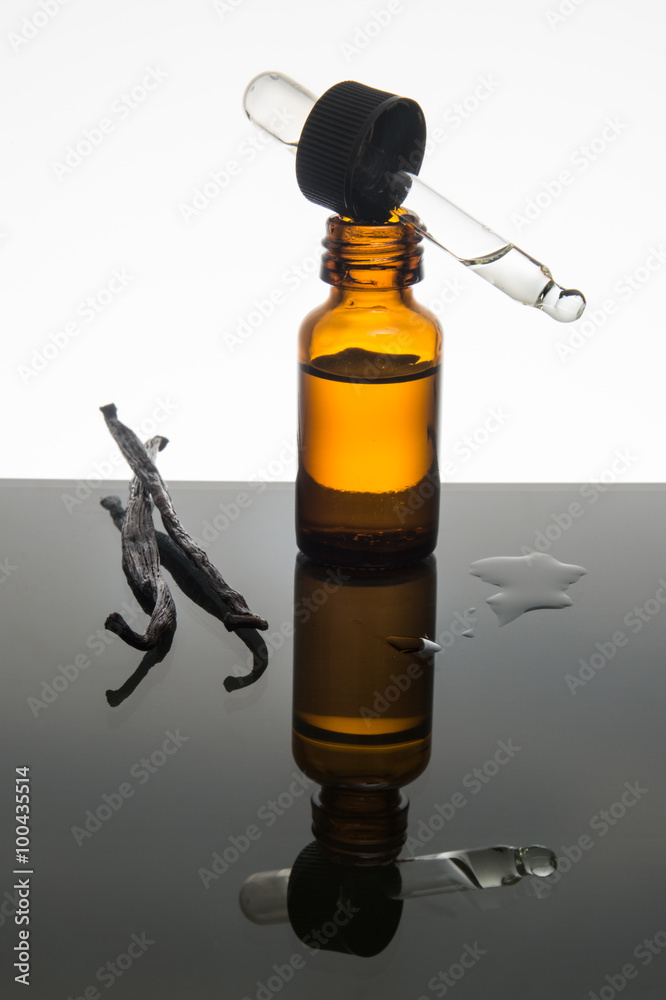 Vanilla beans and vanilla essential oil with amber bottle and dropper Vanilla beans and vanilla essential oil with amber bottle and dropper