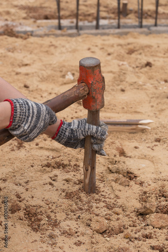 Worker hammering eucalyptus pointed