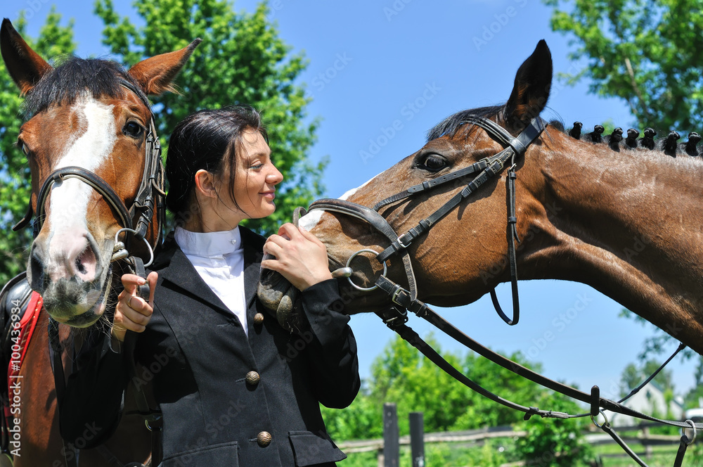 Obraz premium young horsewoman with two horse