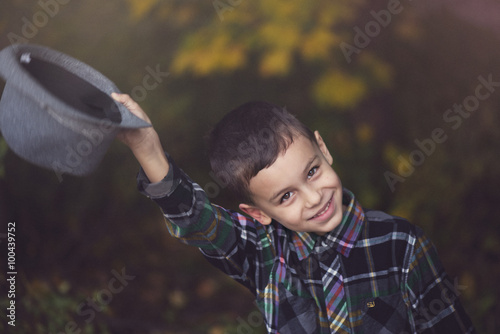 Smiling Boy taking off his hat