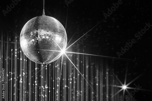 Party disco ball with stars in nightclub with striped walls lit by spotlight, nightlife entertainment industry, monochrome  