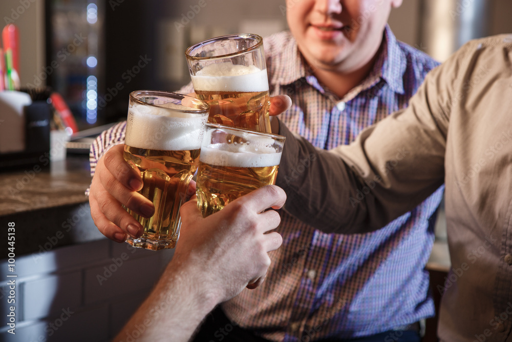 Happy friends drinking beer at counter in pub Happy friends drinking beer at counter in pub