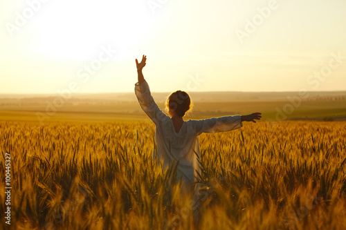 Happy young woman among rye field