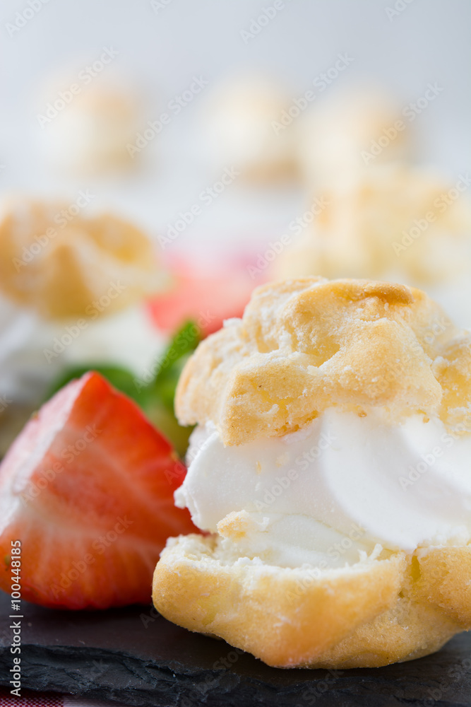 Profiteroles and strawberries on slate
