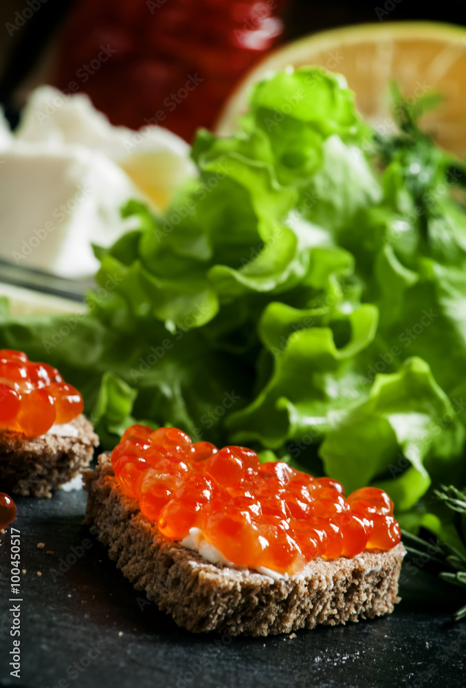 Sandwiches with black rye bread, butter and red salmon caviar on Sandwiches with black rye bread, butter and red salmon caviar on