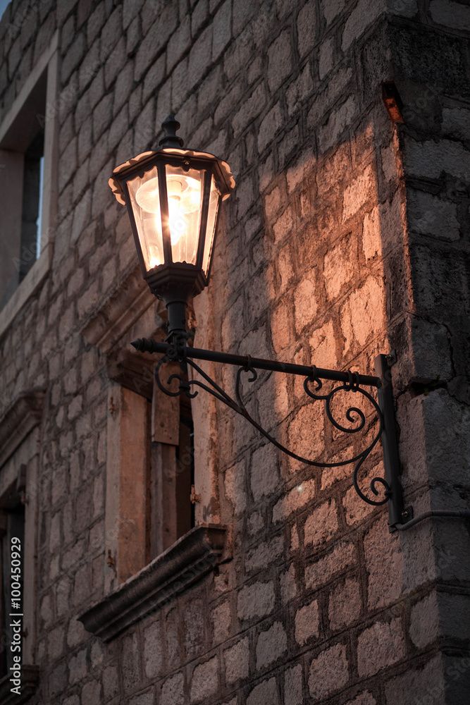 Lantern on the wall lit up at night Lantern on the wall lit up at night
