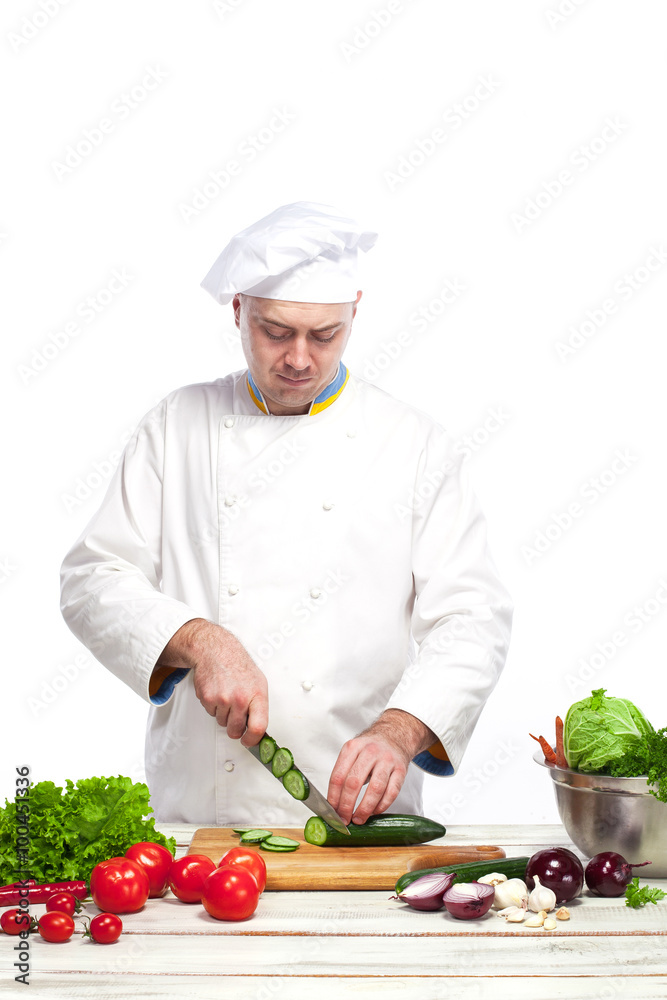 Chef cutting a green cucumber in his kitchen Chef cutting a green cucumber in his kitchen