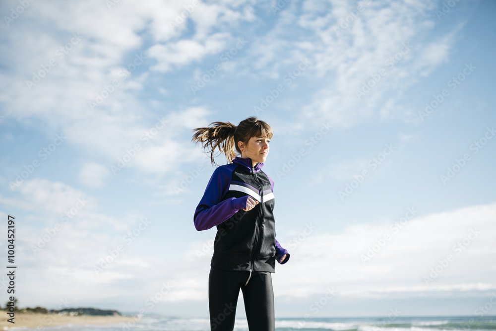 Young beautiful woman running on the beach. Fitness caucasian gi Young beautiful woman running on the beach. Fitness caucasian gi