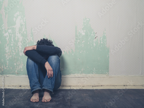 Obraz na plátně Sad young man in empty room