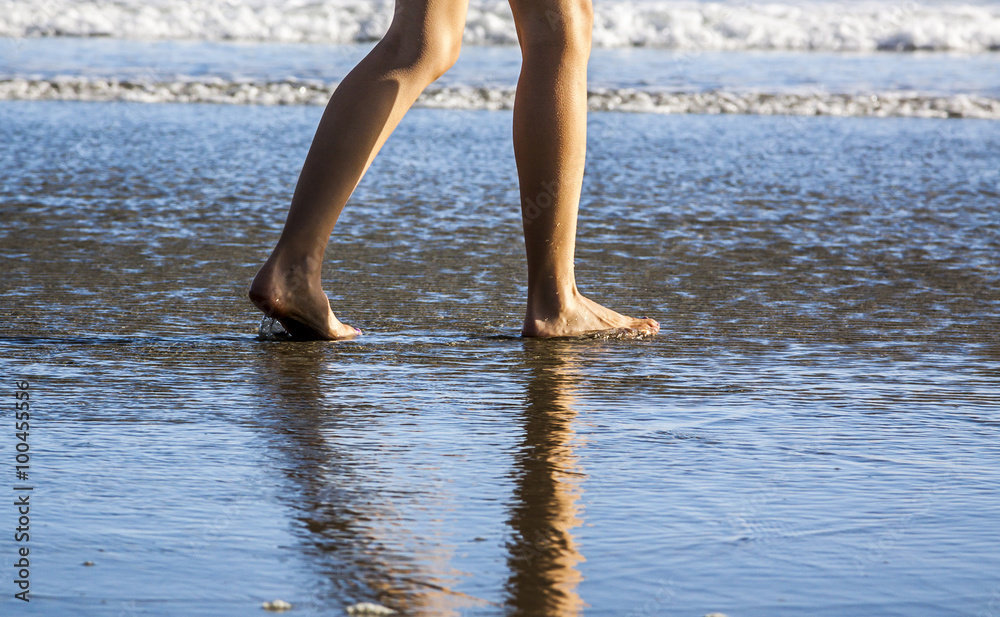 Young Woman's Feet Walking in the Sand and water Young Woman's Feet Walking in the Sand and water