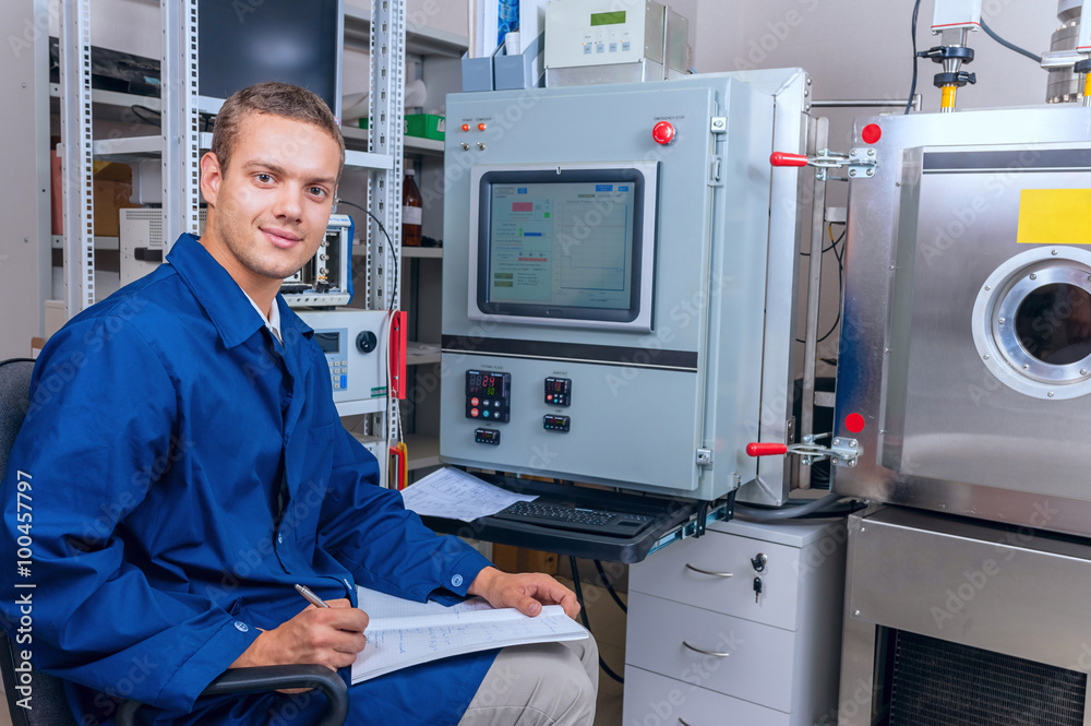 Smiling young male technician records the results of an experiment